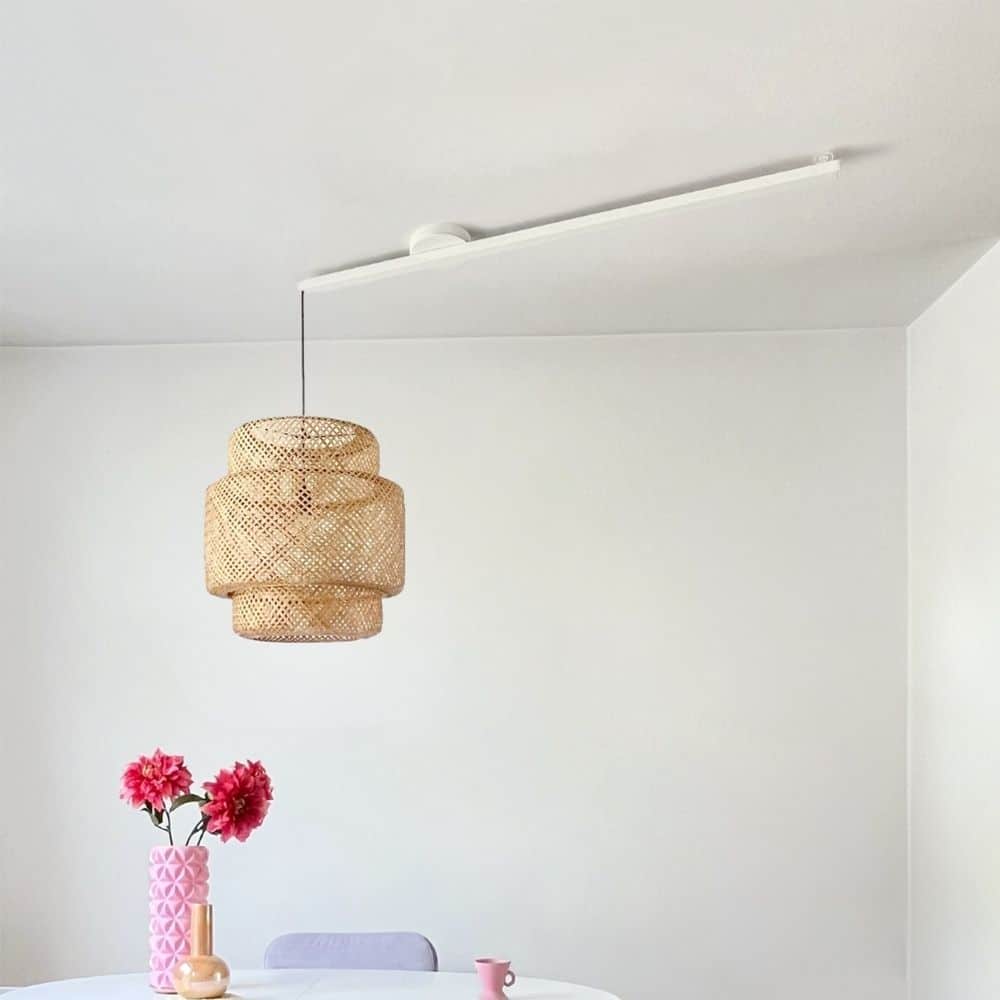 Lightswing® Single Matt White with a rattan pendant light above a dining table with pink vases and flowers in a minimalistic interior