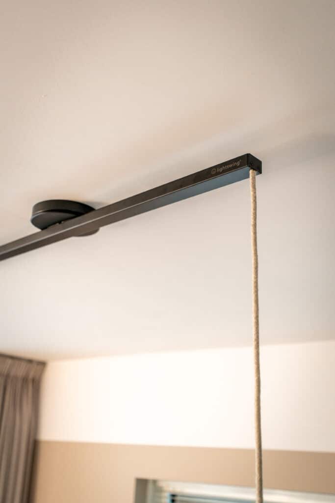 Pendant light on Lightswing® above a dining table in a modern interior