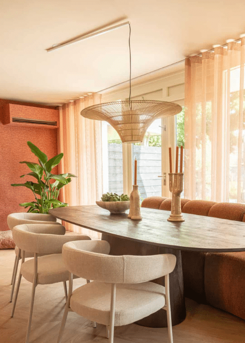 Lightswing® ceiling system with a single pendant light above an oval dining table in a warm, modern interior